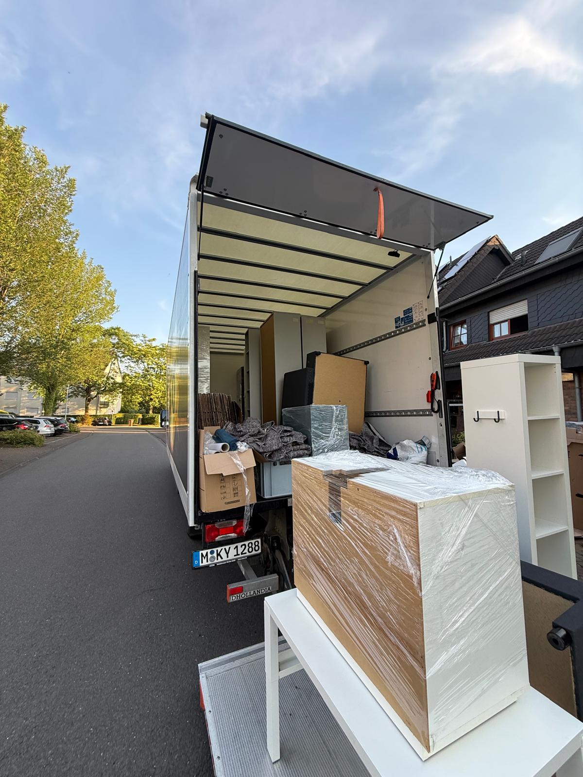 Umzugswagen mit Ladebordwand und verpackten Möbeln