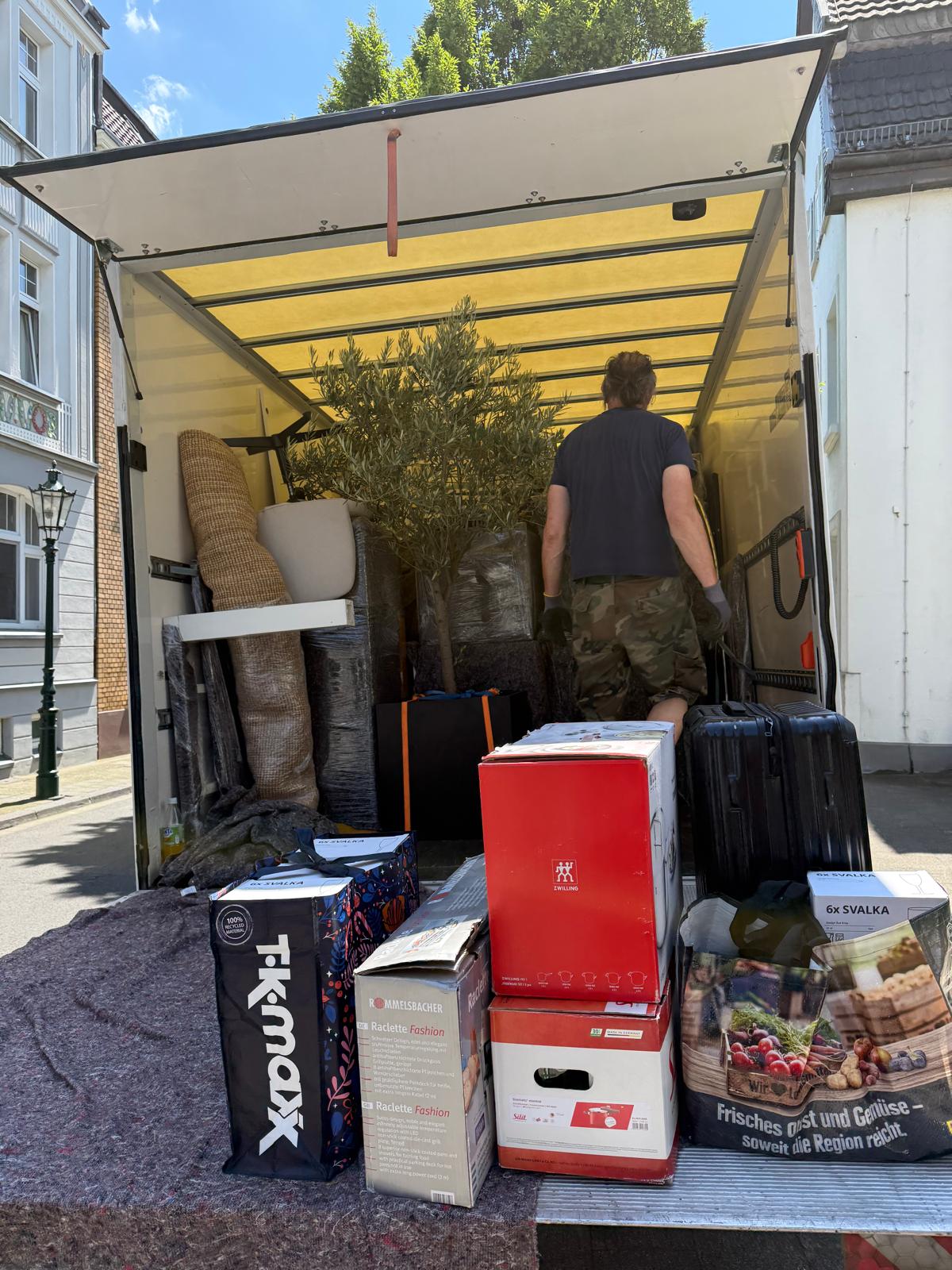 Beladener Umzugs-LKW mit Kartons und Pflanzen